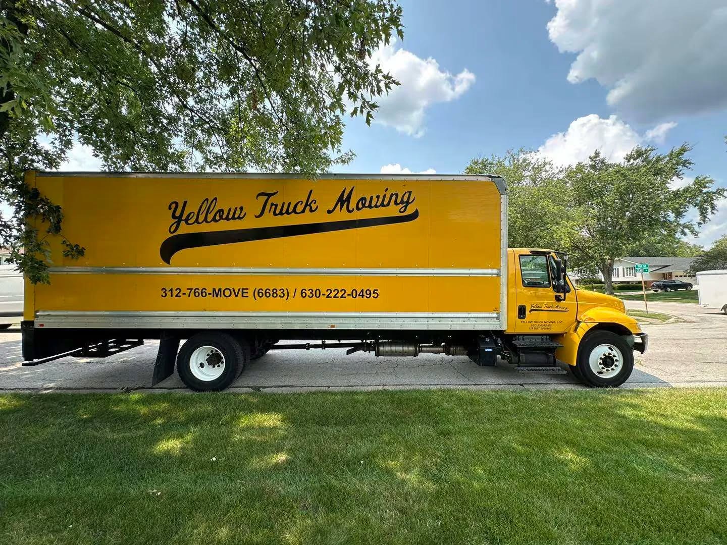 Yellow Truck Moving yellow box truck parked on a tree-lined Chicagoland street