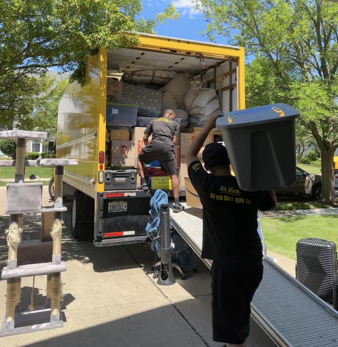 Yellow Truck Moving movers loading boxes and bins into a yellow box truck