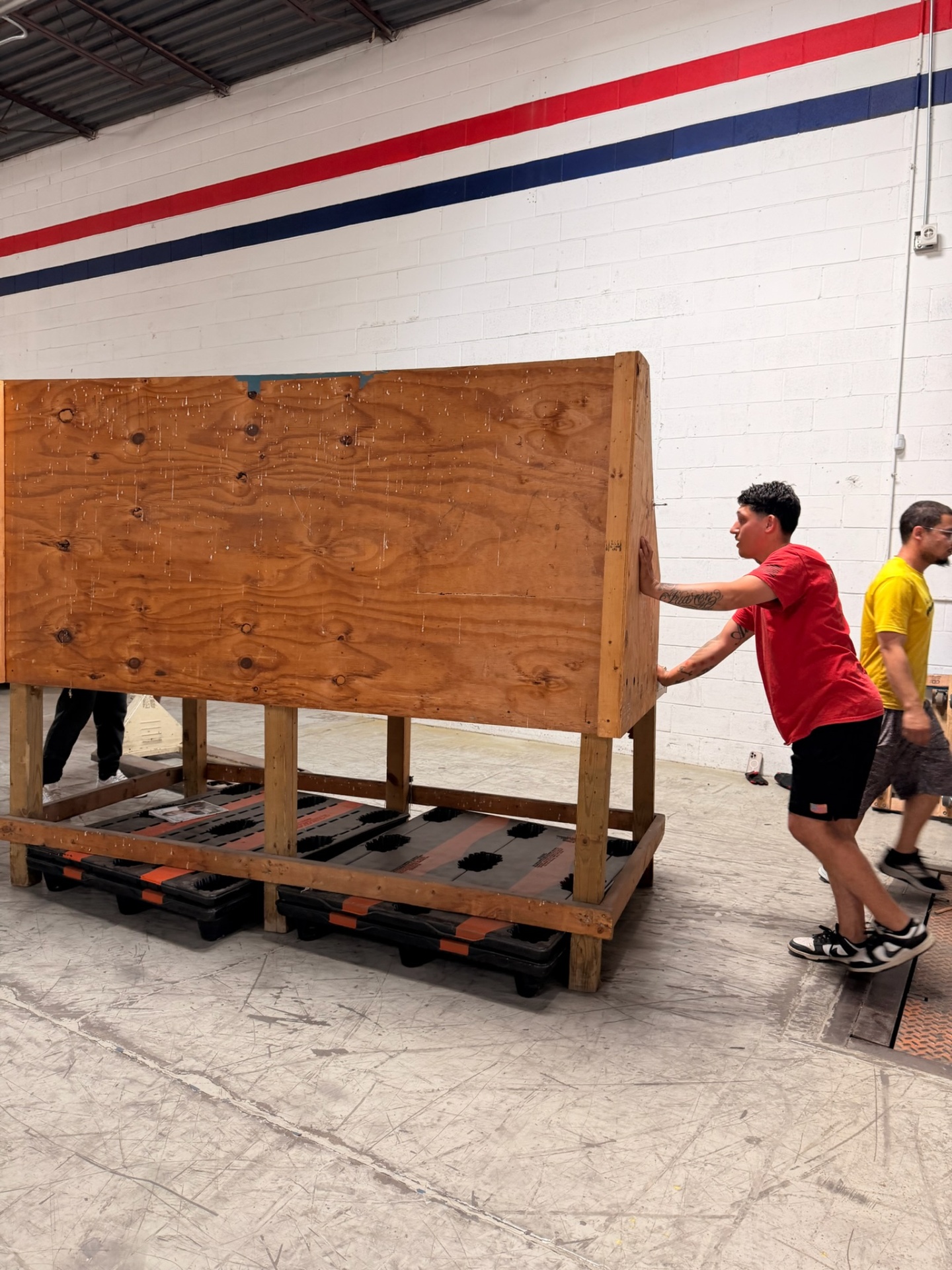 Crew member positioning a wood-crated piece on protective skids
